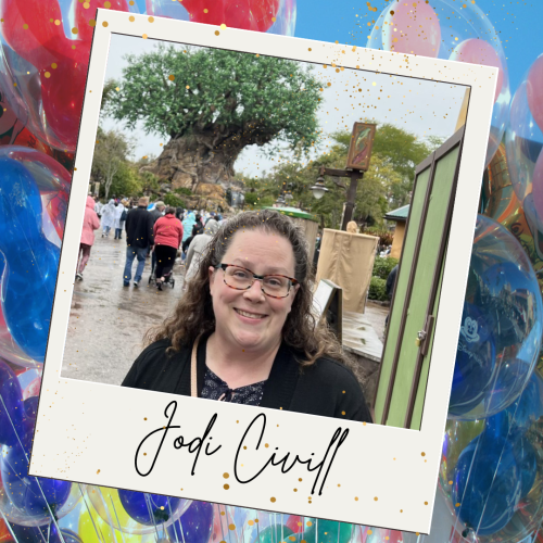 Experienced Travel Agent Jodi Civill stands in front of the Tree of Life at Disney's Animal Kingdom Theme Park on a rainy day.